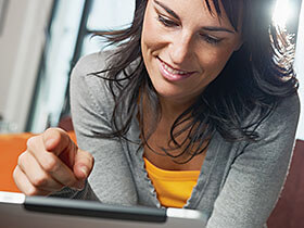 Woman sitting on sofa with tablet pc.